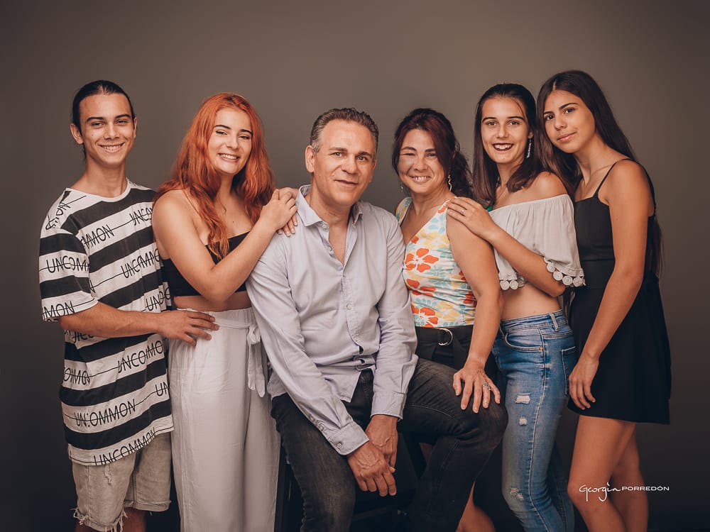 Fotografia de família a Granollers de Georgia Porredón. Sessió d' Estudi de pares i els 3 fills retratats en fons marró fosc molt elegant