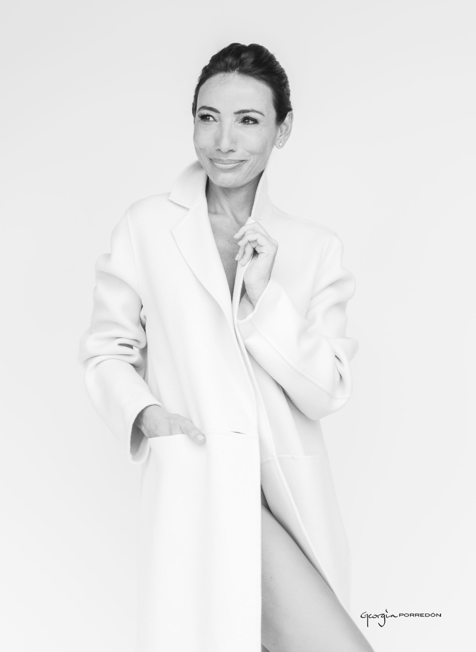 mujer elegante con abrigo blanco retratada por Georgia Porredon en su Estudio posando en blanco y negro
