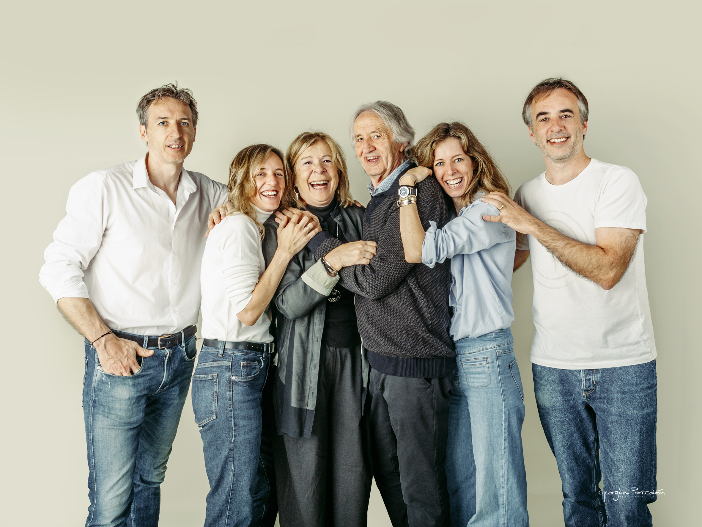 Fotografia de família a Granollers. sessio fotografica de familia on els pares i els fills surten en una posicio relaxada i somrient, autèntica i molt bonica. La mare riu obertament i fa que la composició fotografica sigui natural, acollidora, autèntica i fresca